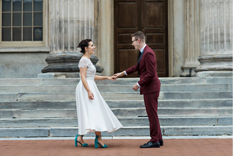 A groom spins his bride around to see her wedding dress.